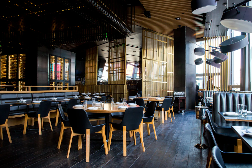 Gemütliche Bistro-Atmosphäre mit warmem Licht und Holztischen.